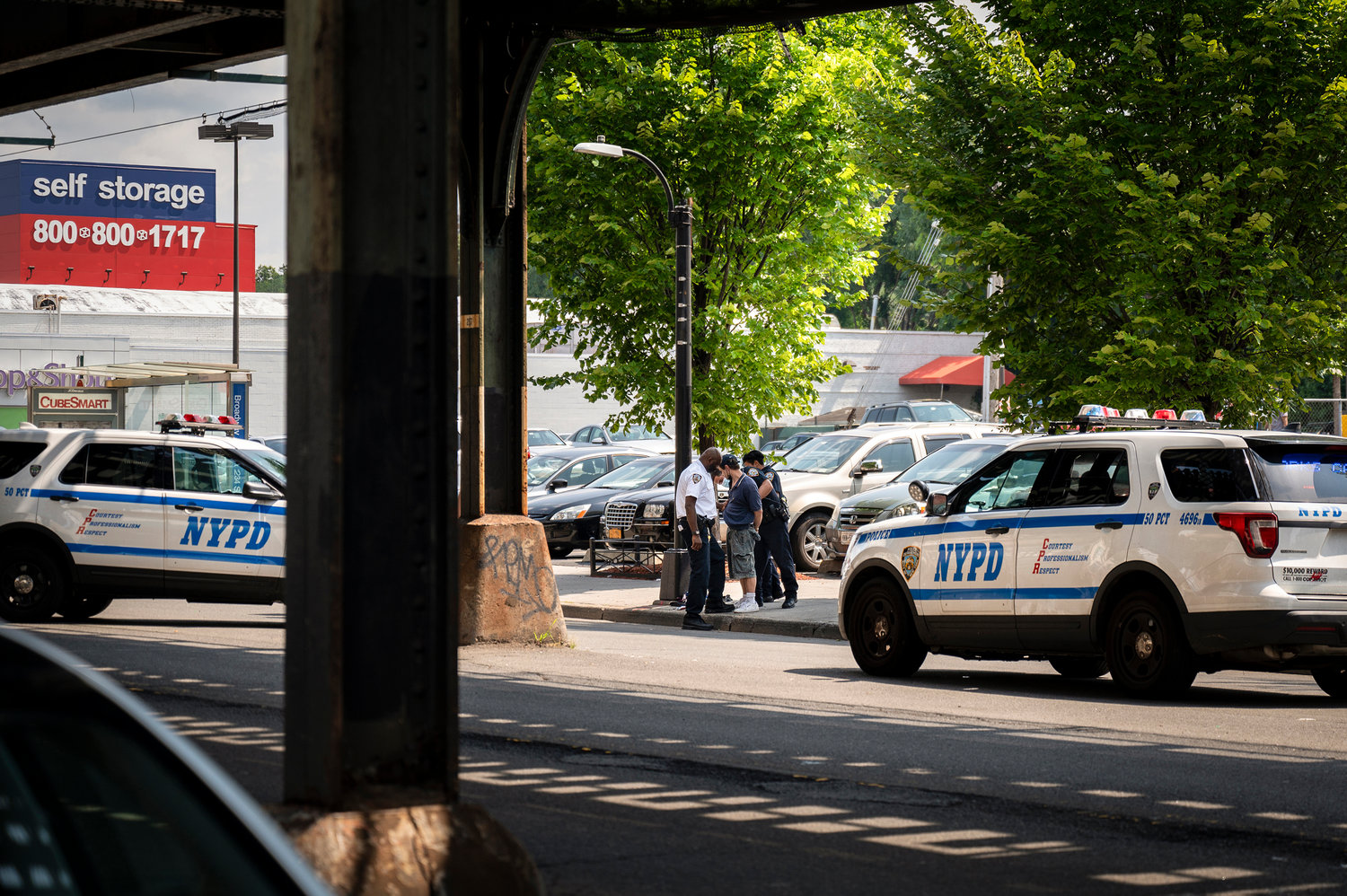Two 50th Precinct squad cars partially block traffic while officers arrest a man near West 233rd Street and Broadway. Over the past two years, the precinct has seen a significant spike in theft of all stripes — including burglary, grand larceny and robbery.