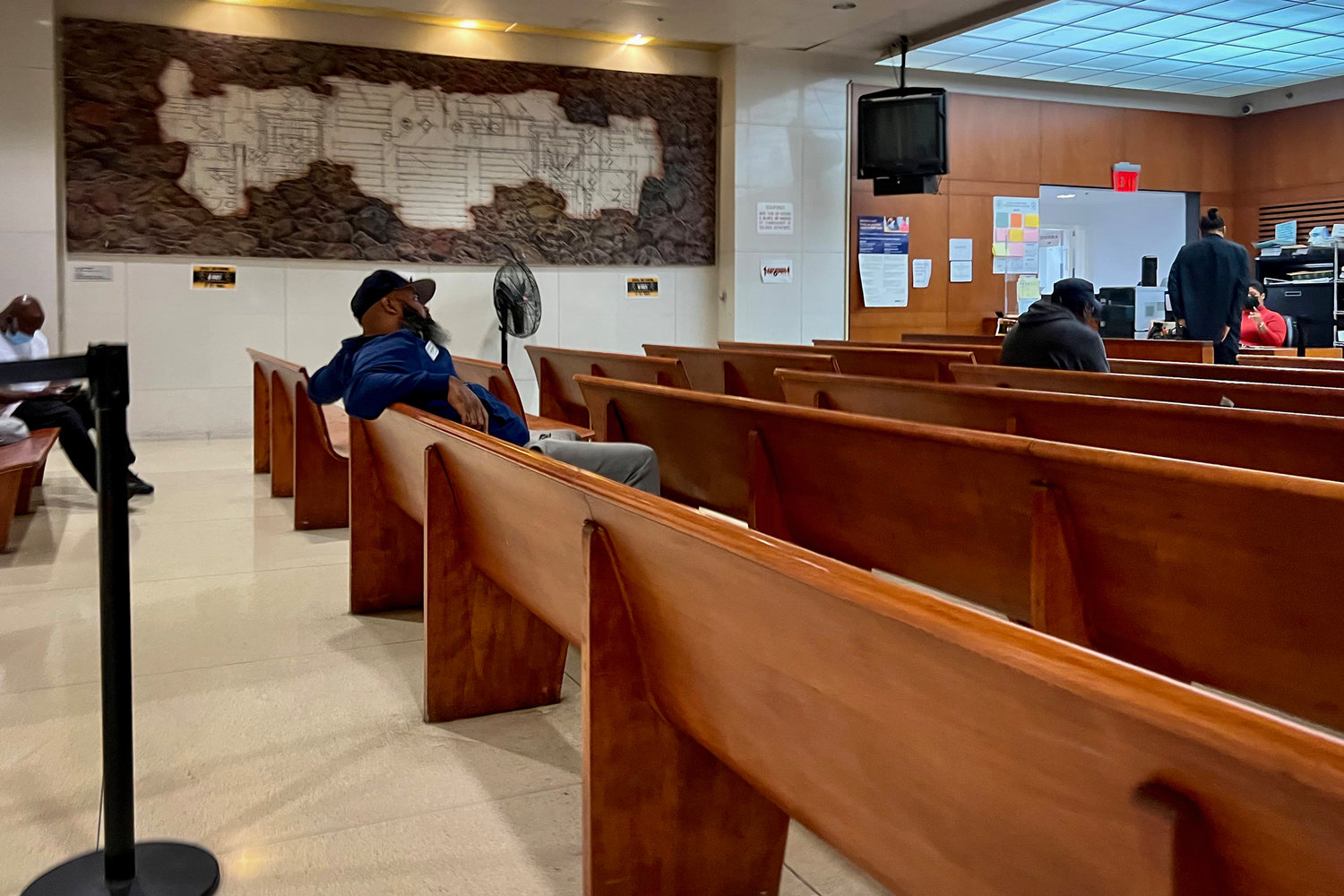 A man waits to speak with a court clerk in Room 230 at Bronx Housing Court, a large courtroom converted into a help center and outfitted with video conference stations for virtual intake in eviction filings. The room had mostly quieted down by 4 p.m. on Sept. 7.