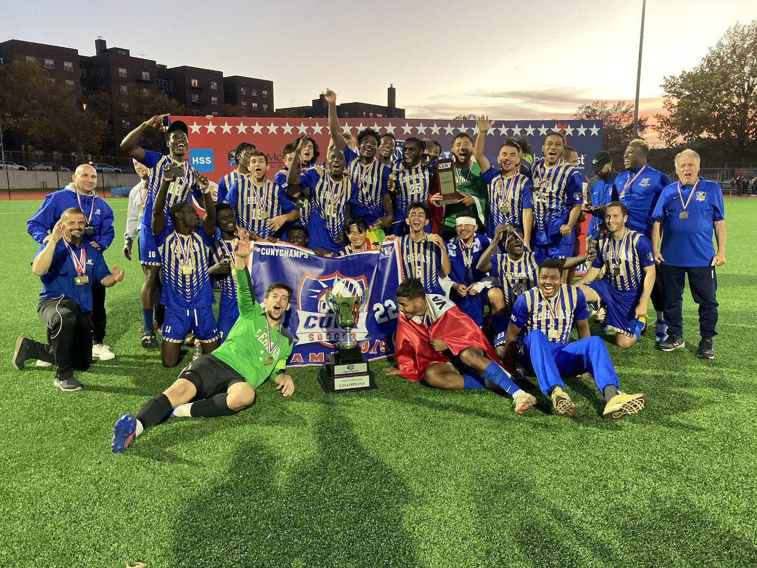 The Lehman College men’s soccer team celebrates with the CUNYAC cup Saturday after defeating Baruch College, 3-1, at Queens College in Flushing.