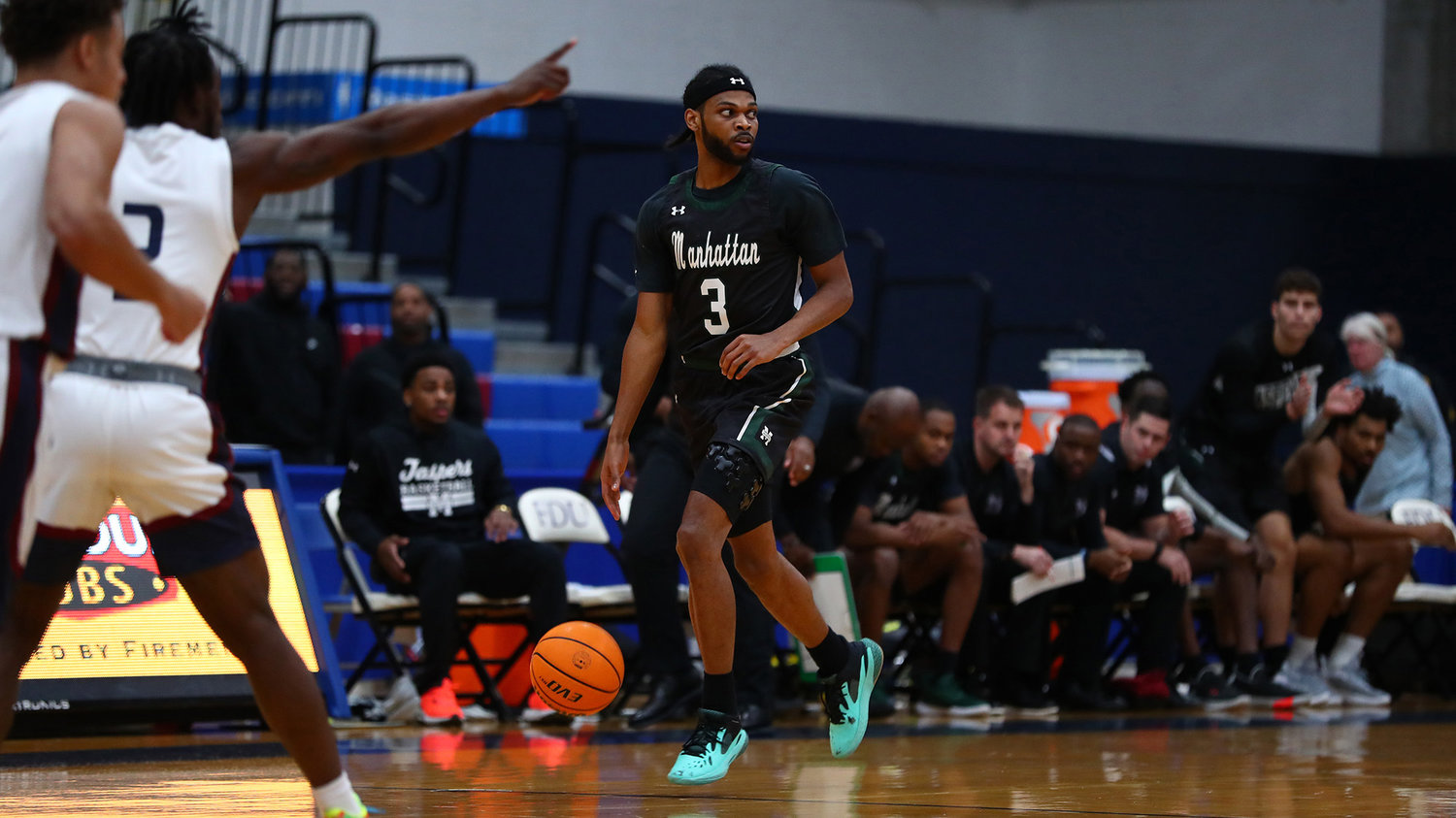 Ant Nelson of Manhattan College looks for a teammate to pass to as he dribbles mid-court in the team’s opening week. The Jaspers are off to an 0-2 start under new coach RaShawn Stores.