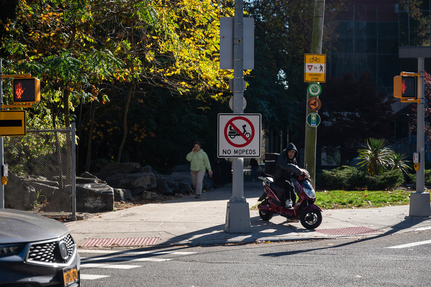 A delivery driver riding a moped on the pathway near Manhattan College’s Kelly Commons is oblivious to the “No Moped” sign that was recently put up there.