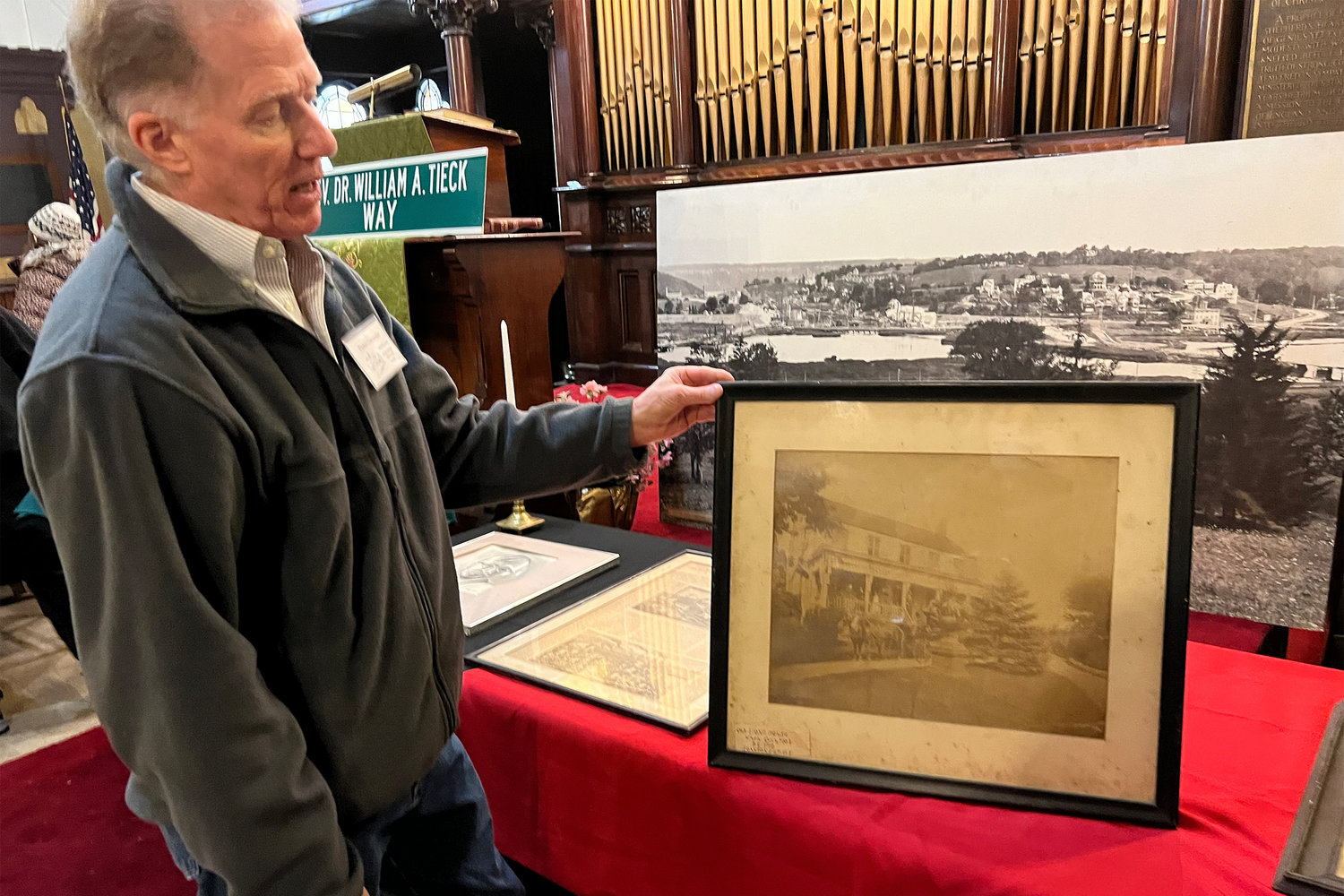 Former Kingsbridge Historical Society president Peter Ostrander shows a photo of a pre-revolutionary home on Kappock Street. That home was taken down by New York urban planner Robert Moses.