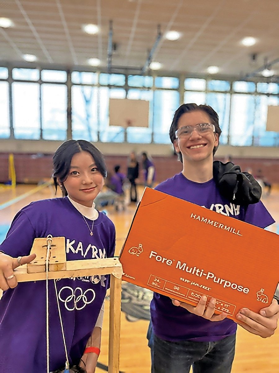 Esther Luo, left, and Storm Garcia show off their ‘Scrambler’ after the Science Olympiad regional conference. They finished second.