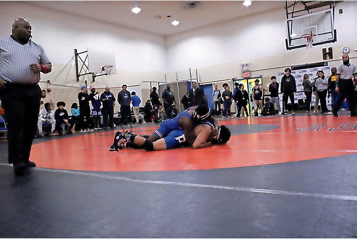 RKA wrestler Tab-e-Tar Agborenow on top of his opponent at the city championships where he went on to finish first place and qualify for states.