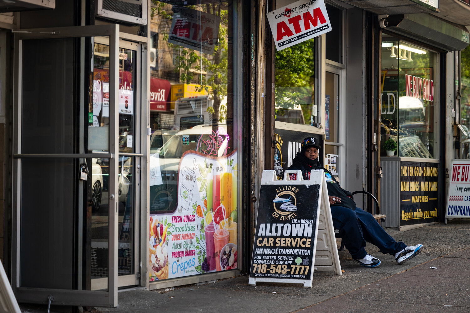 A security guard sits outside of 206 W 231st Street, the smoke shop that was raided, on Wednesday, April 19.