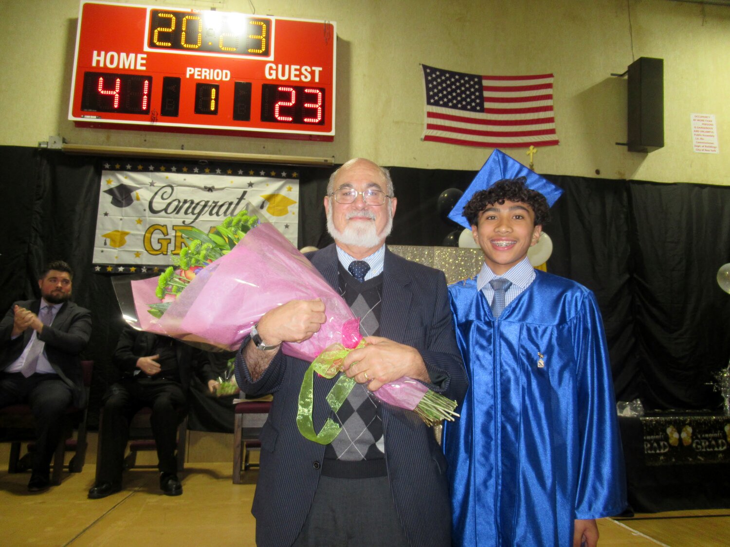 Mr.McCarthy being handed flowers at Saint Gabriel final graduation on June 9, 2023.