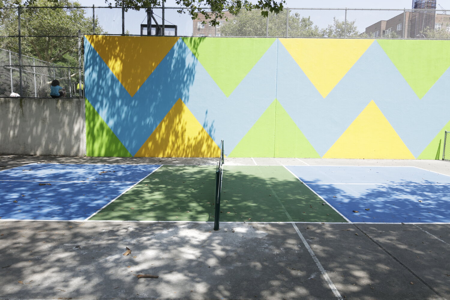 The newly installed pickleball court at Riverdale Playground is adjacent to handball courts.  Sometimes balls in play during pickleball wind up on the handball courts because there is no fence.