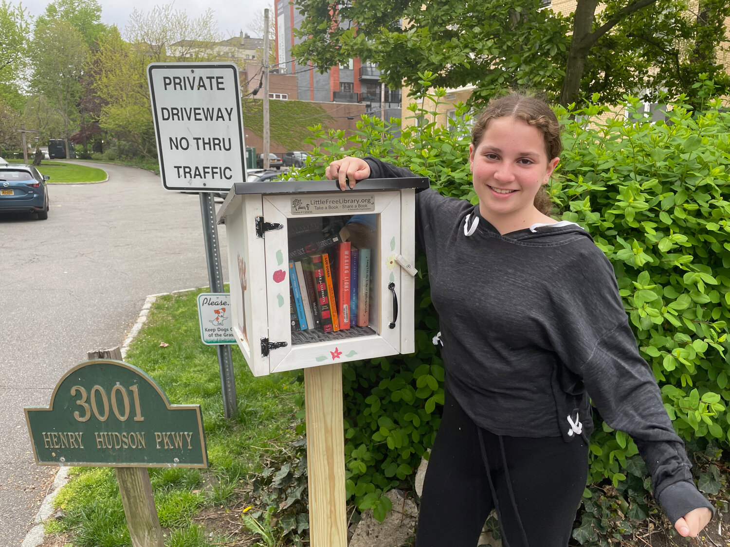 Sigal Teten stands next to her Little Free Library organized by for her Bat Mitzvah project last October. This little library is one of approximately three in Riverdale. Teten painted the box herself, which is at 3001 Henry Hudson Parkway.