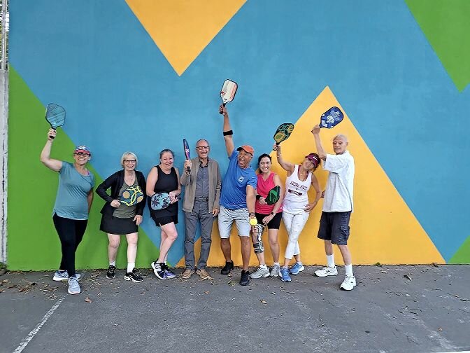 A group of pickleball players strike a pose as they met up at the newly installed court at Riverdale Playground Aug. 8 to celebrate National Pickleball Day.