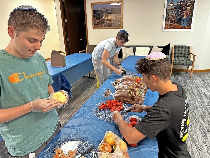 Adam Burian, left, is makes lunches for hundreds of people seeking asylum with fellow volunteer Harrison Brooks. They helped feed families and children. The volunteers did much more than meal preparation. They distributed clothing and medicine like Narcan, which rapidly reversed the effects from an opioid overdose.