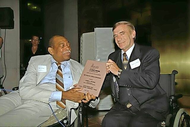 Junius Kellogg was the first African American basketball player in the history of Manhattan College and was later paralyzed in car accident. Years later, he was honored by Jim Peters, executive director of the Eastern Paralyzed Veterans Association.