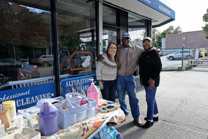 Nanda Chaves, Kiwanis president, enjoys time during a break with two people who helped with the window painting event Sunday.
