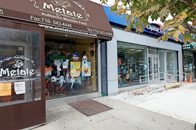 Painted ghosts on windows greet customers at Metate Mexican food eatery.