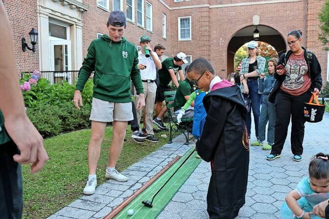 A student dressed up as a Harry Potter wizard practices his putting on the miniature golf course at Manhattan College during the annual Halloween celebration on Oct. 27.