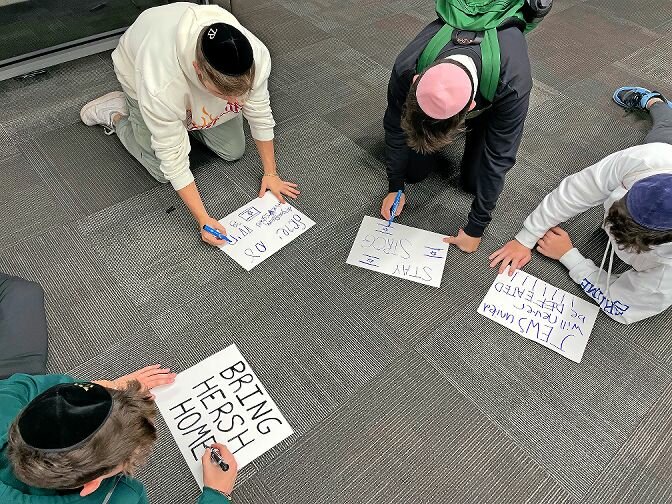 Students at SAR High School create signs they took to the March for Israel on Tuesday in Washington, D.C. One of the signs stated "Bring Hersh Home" in reference to the son of a friend of Rabbi Jonathan Kroll, principal of the high school, who is being held hostage in Gaza. His name is Hersh Goldberg Polin.