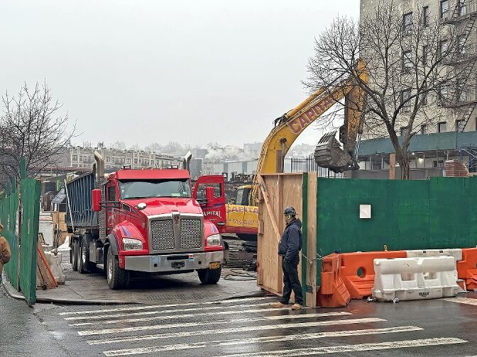 Construction workers use heavy equipment to finish up demolition of what remains of five storefront businesses along West 231st Street near Broadway. An early morning fire last December — blamed on an electrical issue started in the kitchen of Cold Cut Bunny Deli — destroyed them.