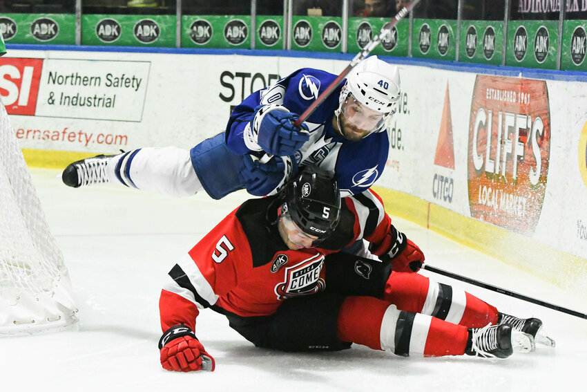 Utica Comets defenseman Robbie Russo (5) is hit by Syracuse Crunch player Gabriel Dumont during a meeting between the North Division rivals. The teams meet Friday in Utica and Sunday in Syracuse. It is among five meetings between the teams before the end of the regular-season on Saturday, April 15.