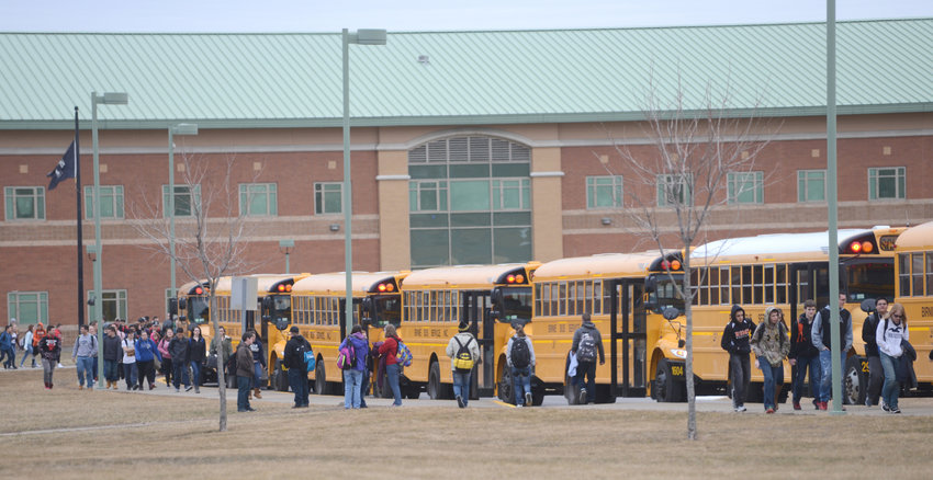 GET COMFORTABLE &mdash; Rome Free Academy students walk to their buses after dismissal from school in this file photo. Members of the district&rsquo;s Board of Education were critical of early pickups and long bus rides during a special meeting on Thursday.