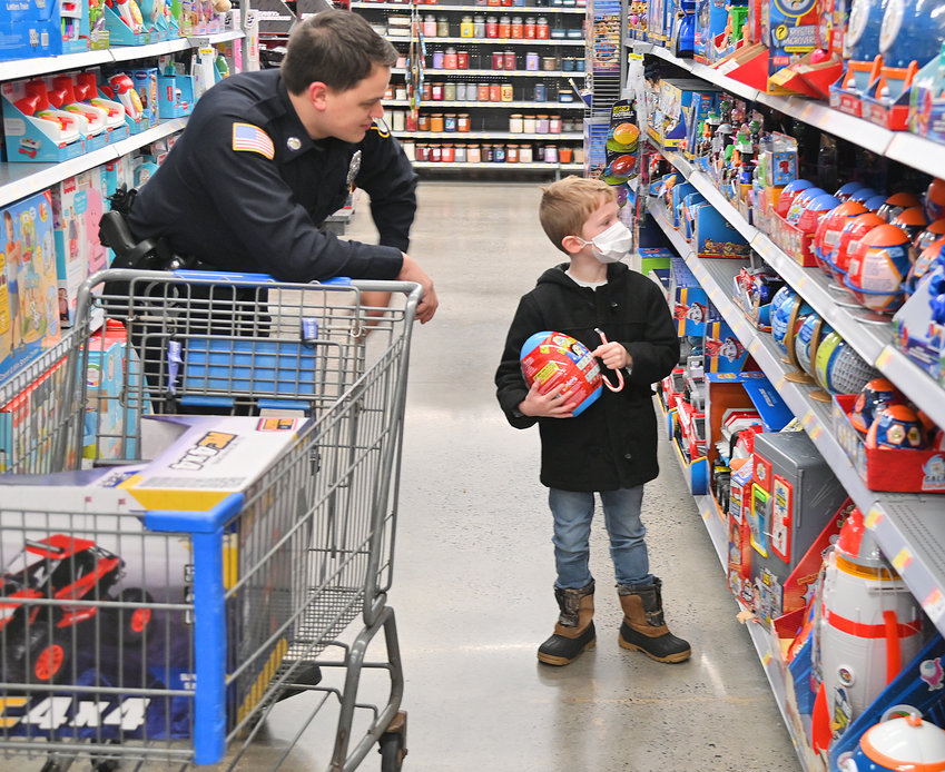 HOW&rsquo;S THIS ONE? &mdash; Rome Police Patrolman Zack Hadaz helps 7-year-old Travis Swett pick out toys during the Rome Shop with a Cop event Saturday morning at Walmart on Rome-Taberg Road.