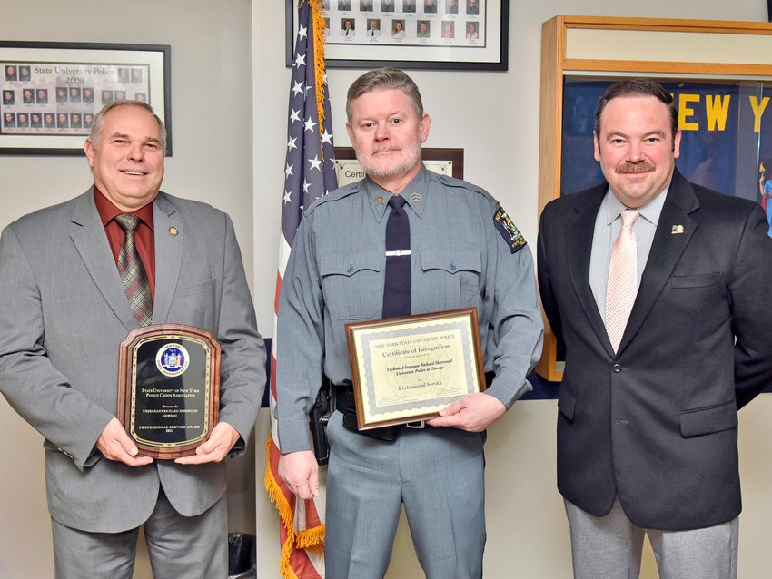 AWARD FOR SERVICE &mdash; Tech. Sgt. Richard Sherwood, center, of the State University of New York at Oswego Police received the 2021 SUNY University Police Professional Service Award, which honors officers state-wide for demonstrating heroism and professional commitment to public safety, during a recent ceremony. From left: SUNY Oswego University Police Chief Kevin Velzy; Sherwood; and Assistant Chief Scott Swayze.