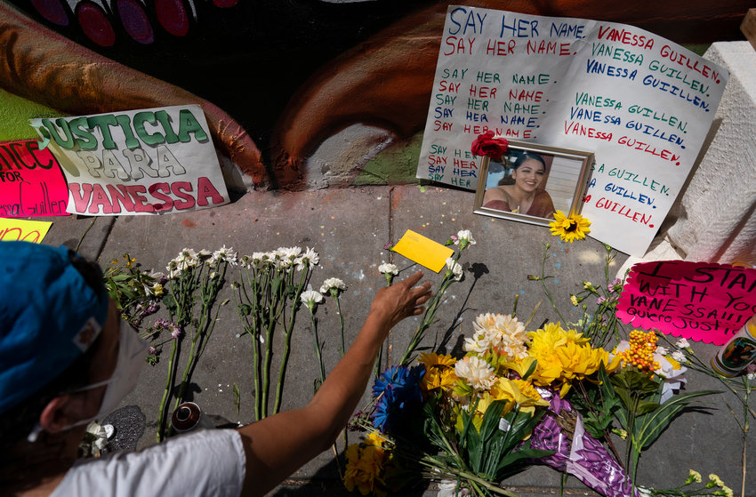 IN MEMORIAM &mdash; Frida Larios places flowers near a photograph of slain Army Spc. Vanessa Guillen in Washington. Guillen was killed by a soldier, who her family says sexually harassed her, and who killed himself as police sought to arrest him.