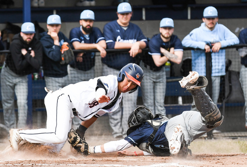 PLAY AT THE DISH &mdash; Utica University player John Son, left, attempts to slide around a tag from Cazenovia catcher Joe Brisson during a baseball game on Tuesday in Utica. Son was out on the play. The Pioneers won 5-2 to earn their 10th win of the season.