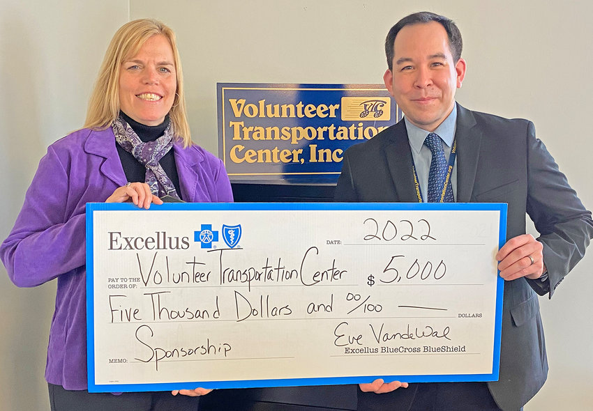 OVERCOMING TRANSPORTATION BARRIERS &mdash; Jeremiah S. Papineau, foundation director for the Volunteer Transportation Center, Inc., holds a ceremonial check with Eve Van de Wal, Excellus BlueCross BlueShield Utica regional president. The health plan awarded the VTC $5,000 in support of the services provided to people in the community facing transportation barriers.