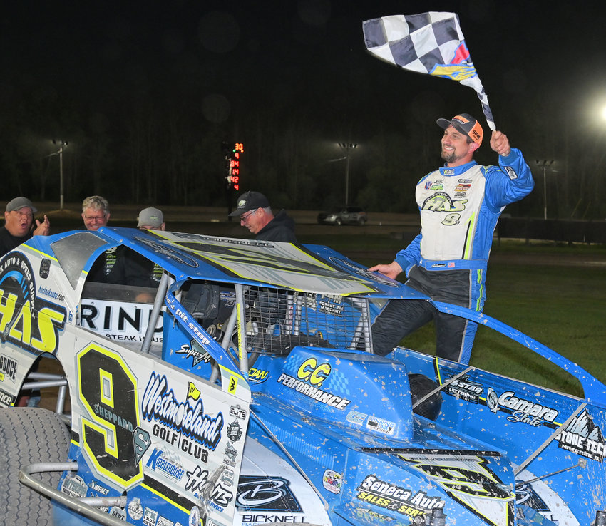 WAVING THE CHECKERED FLAG &mdash; &quot;Super&quot; Matt Sheppard, of Savannah, waves the checkered flag and is $4,000 richer after winning the 30-lap Thunder on the Thruway feature race Friday night at Utica-Rome Speedway.