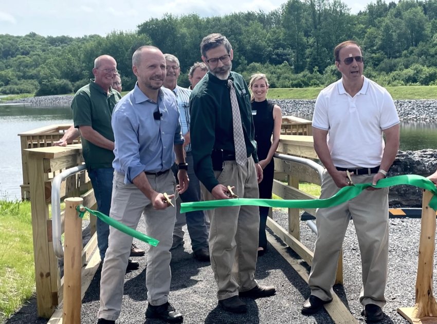 State and local officials gather to cut the ribbon and mark the completion of a renovation and rehabilitation project at Chittning Pond in Sangerfield on Thursday.