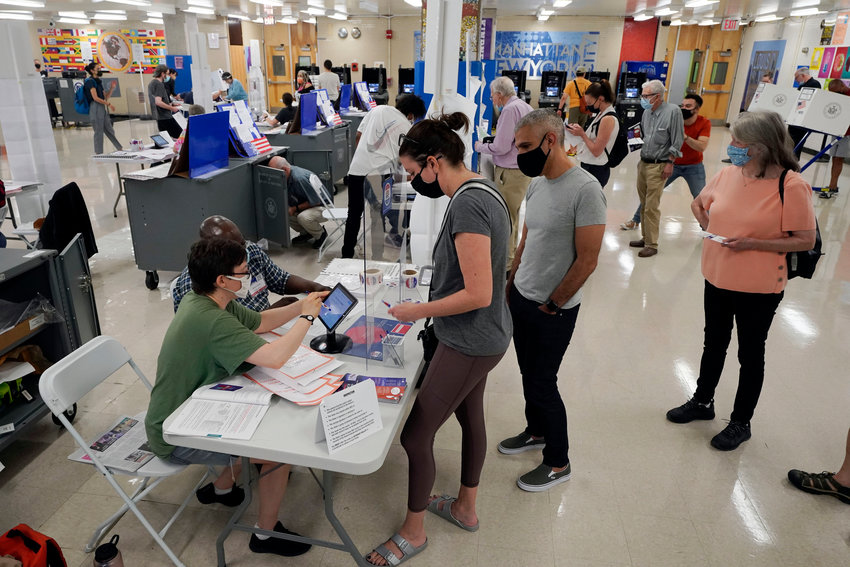 Voters sign in at Frank McCourt High School in New York City in this file photo from 2021. New York&rsquo;s governor has signed a law intended to prevent local officials from enacting rules that might suppress people&rsquo;s voting rights because of  their race.