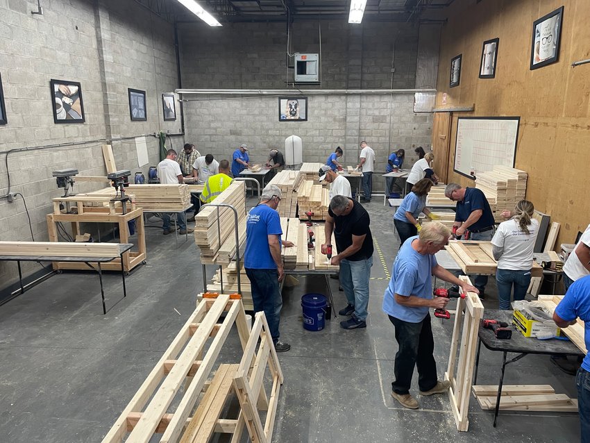 Volunteers turn boards into beds to make a lasting difference in the lives of children in need as part of a build by volunteers from the local chapter of Sleep in Heavenly Peace and National Grid on Thursday at the Meyda Tiffany factory in Yorkville.