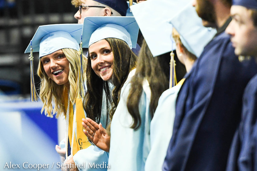 From left, graduates Mackenzy Doremus and Emma Donahue wave toward the crowd during the annual commencement ceremony for Central Valley Academy on Saturday at the Adirondack Bank Center at the Utica Memorial Auditorium.
