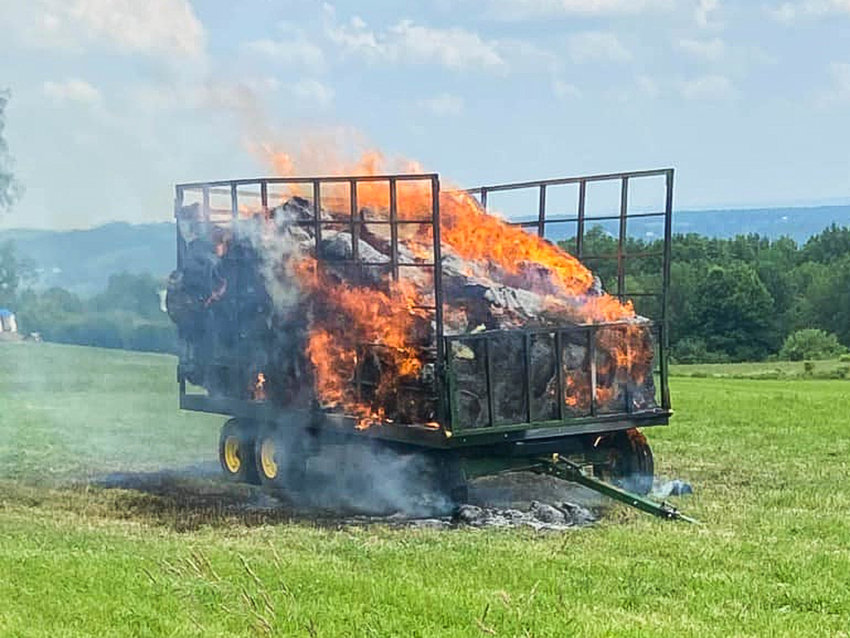 A wagon full of hay burns in a field off Quaker Hill Road in the Town of Western Sunday afternoon. Local volunteers responded and doused the blaze. Tightly packed hay is known to spontaneously combust, and temperatures reached nearly 90 degrees on Sunday.