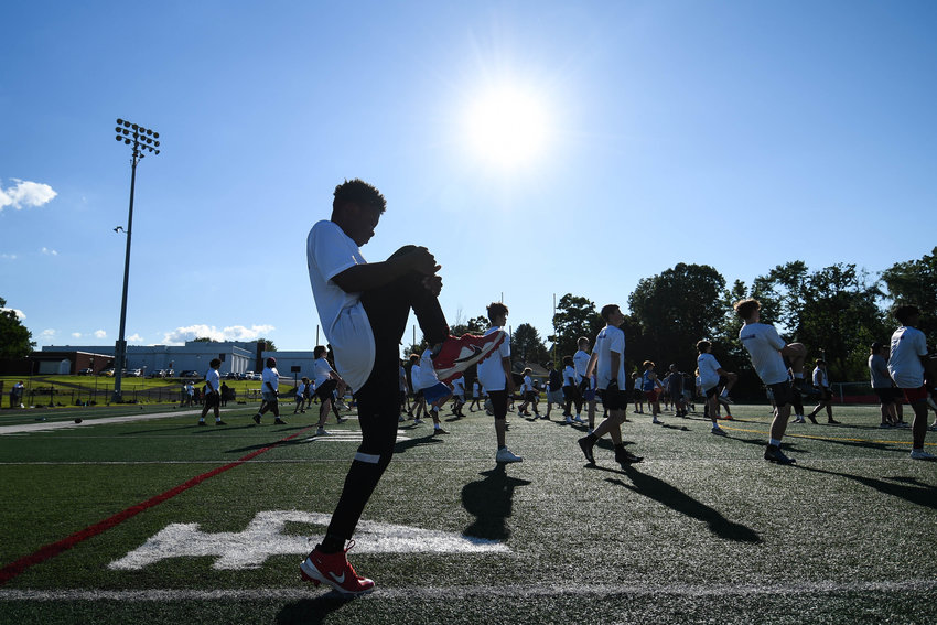 WARMING UP &mdash; Teen athletes warm up on the field during the fifth annual &quot;A Call to Men&quot; football camp on Tuesday at Charles A. Gaetano Stadium at Utica University.