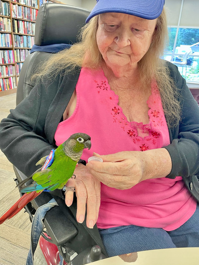 Marsha Moreland, of Rome, gives her green-cheeked conure, Sky, a drink of water while visiting Jervis Public Library on North Washington Street. Sky is a registered Emotional Support Animal and has come to Moreland&rsquo;s assistance on several occasions.