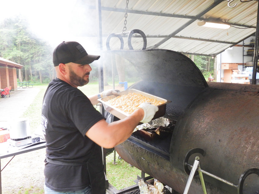 Taste of Oneida County saw hundreds of people flock to Verona Beach State Park on Friday, July 1 to sample and taste food from local businesses who set up their trucks and stalls. Pictured is one of the chefs of Cowboy BBQ, pulling a pan of smoked mac and cheese out for hungry customers.