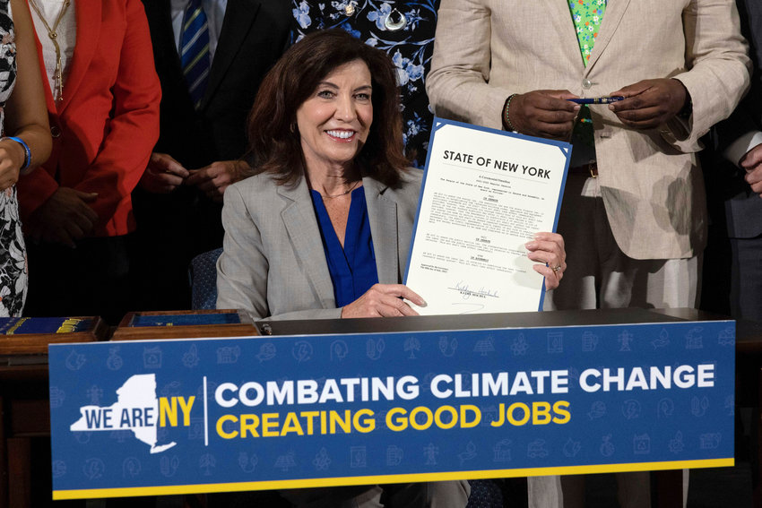Gov. Kathy Hochul shows a signed legislative package to reduce greenhouse gas emissions and create green jobs during a press conference, Tuesday at the Brooklyn Navy Yard in the Brooklyn.