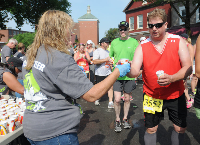 Runners flooding the streets of Utica grabbing water on the way to the post race party in this 2015 file photo. This year, officials again urge caution on streets near the race, as there once again will be large groups congregating.