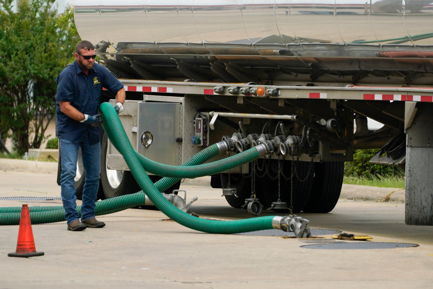 A gas tank driver adjusts his hose hookup to an underground tank on May 24, 2022, in Jackson, Miss. High diesel prices are driving up the cost of most goods, from groceries to Amazon orders and furniture, as nearly everything that is delivered, whether by truck, rail or ship, uses diesel fuel. Truckers are turning down hauling jobs in the states with the most expensive diesel.