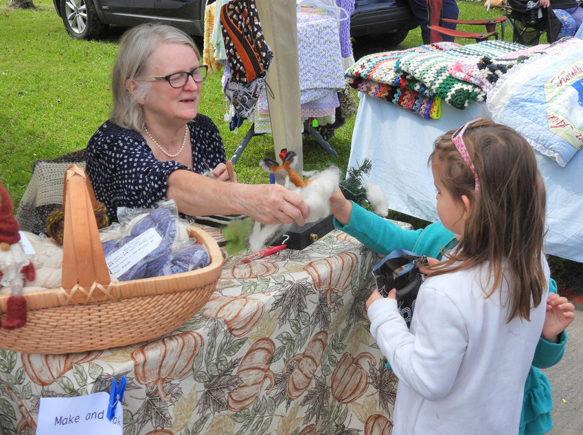 Linda Faber of Faber Farm in Camden shows local children the kind of wool she gets from her sheep farm and how she uses it to make all kinds of crafts via felting at last year&rsquo;s Fall Fest in Oneida.