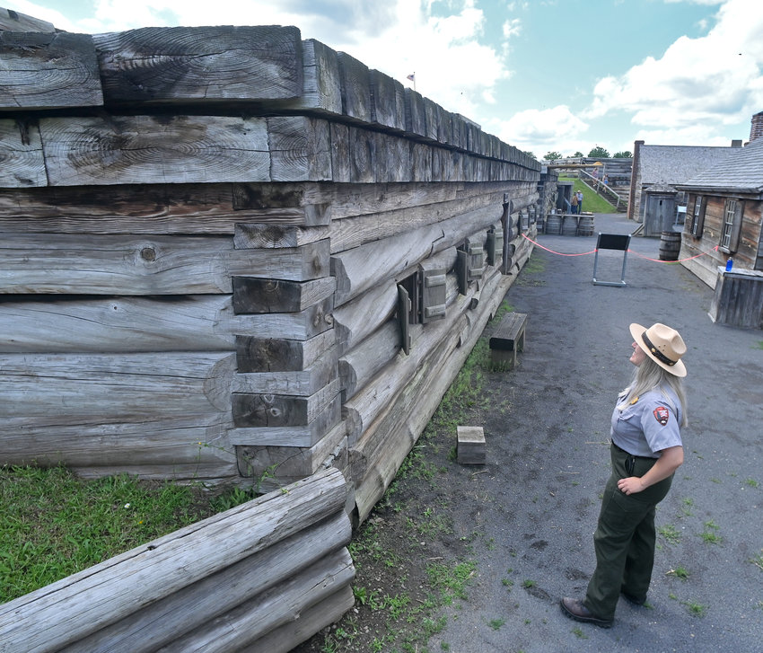 Fort Stanwix National Monument Park Ranger Meaghen Gape looks up to the spot on the corner of the southeast barracks &mdash; the location of a honeybee hive that recently swarmed. The area is roped off to prevent visitors from getting stung, while giving the active hive peace before they can be removed by a professional beekeeper.