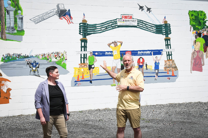 Officials unveiled the completed Boilermaker Mural which decorates the wall of the Boilermaker Road Race headquarters in Utica. The work was re-created by local artist and runner Rachel Olson, left, pictured with Boilermaker president Mark Donovan.