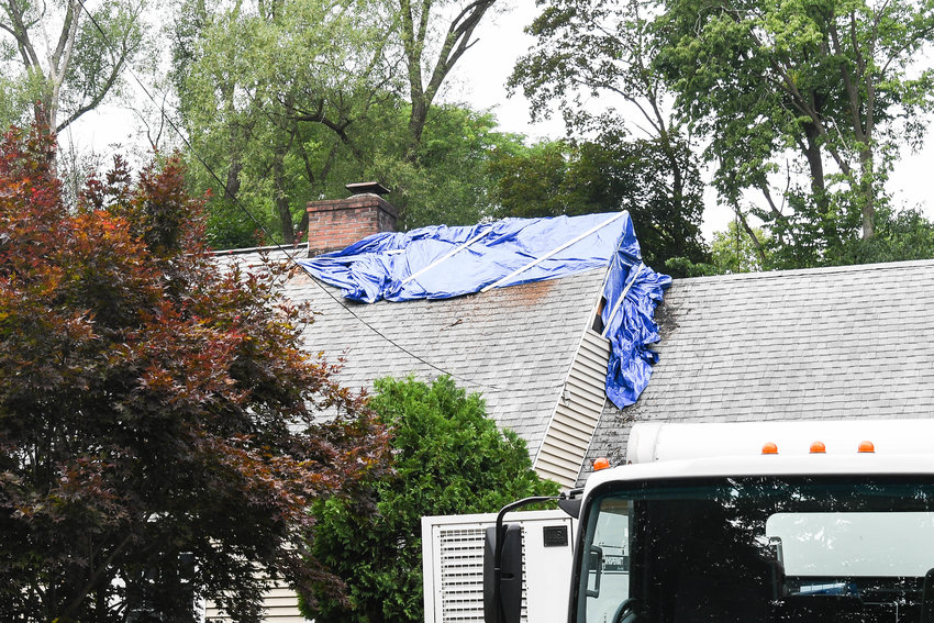 Tarp covers the fire damage at 2 Woodberry Road in New Hartford following a fire early Tuesday morning. Police said one resident remains in critical condition at a Syracuse hospital.