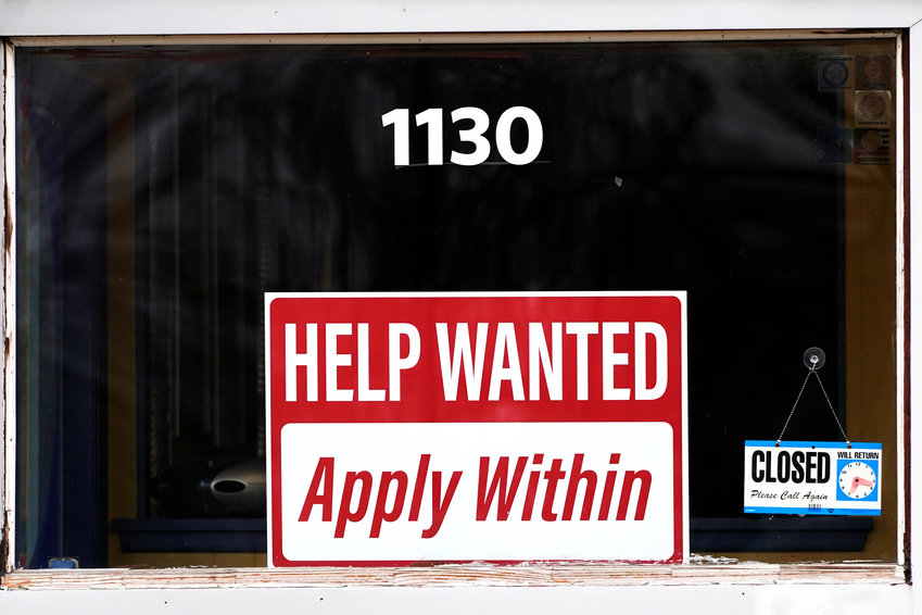 A &quot;help wanted&quot; sign is seen at an Allstate insurance office in Elgin, Ill., March 19, 2022. American employers posted fewer job openings in June as the economy contends with raging inflation and rising interest rates. Job openings fell to a still-high 10.7 million in June from 11.3 million in May, the Labor Department said Tuesday, Aug. 2, 2022.