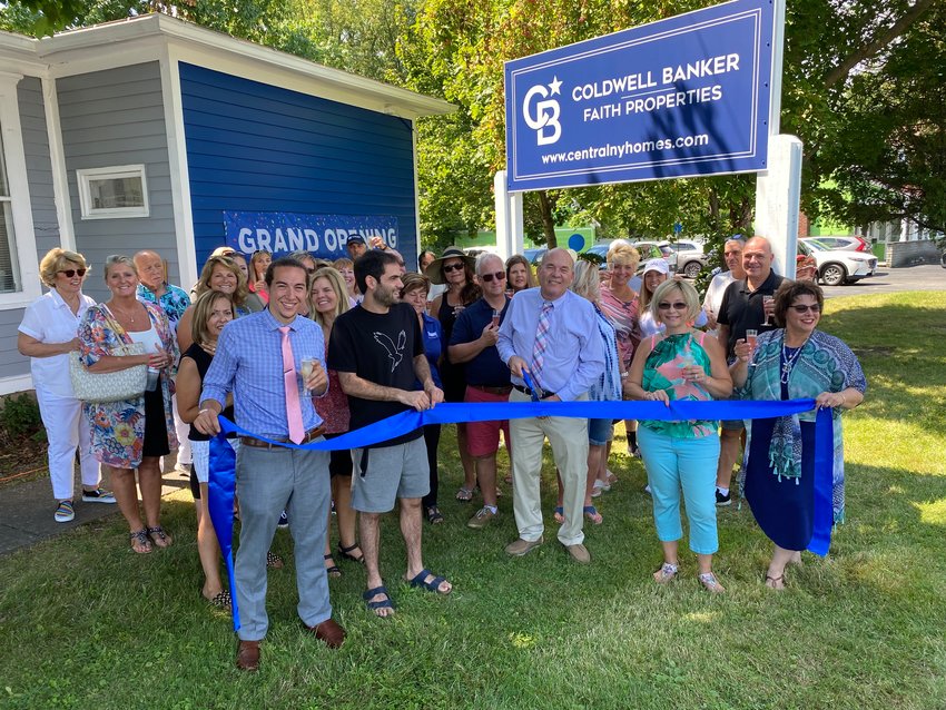 Employees of Coldwell Banker Faith Properties, along with Owner/Broker John Brown, center, at a ribbon cutting at its newest location in Sherrill on Monday, Aug. 15, 2022.