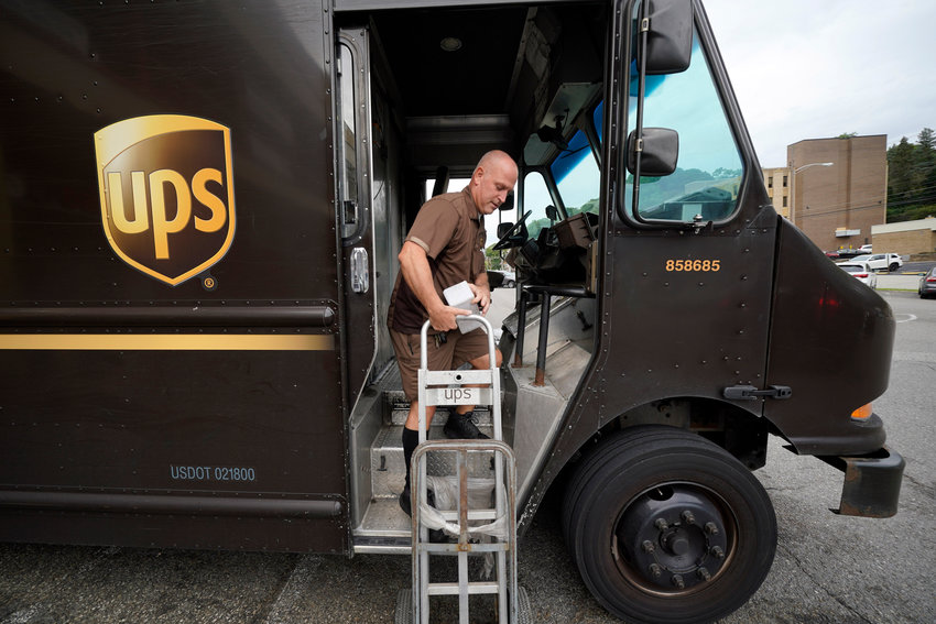 UPS driver Joe Speeler makes a delivery at the Leanon Shops in Mount Lebanon, Pa., on Tuesday, Sept. 21, 2021. United Parcel Service said Wednesday, Sept 7, 2022, it plans to hire more than 100,000 extra workers to help handle an increase in packages during the critical holiday season.