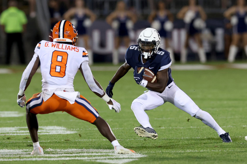 Connecticut wide receiver Aaron Turner runs downfield as Syracuse defensive back Garrett Williams defends during a non-league game on Saturday night in East Hartford, Conn.