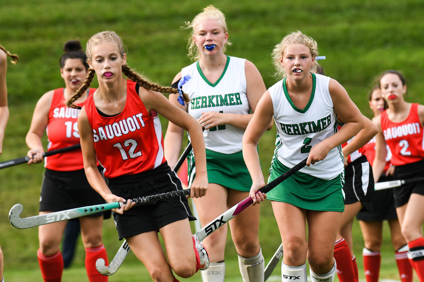 Sauquoit Valley&rsquo;s Emilie Fancett (12) runs down the ball with Herkimer defenders Emily Marquissee and Audrey McDonnell (2) giving chase during the Center State Conference field hockey game on Monday in Herkimer. The two teams played to a scoreless result.