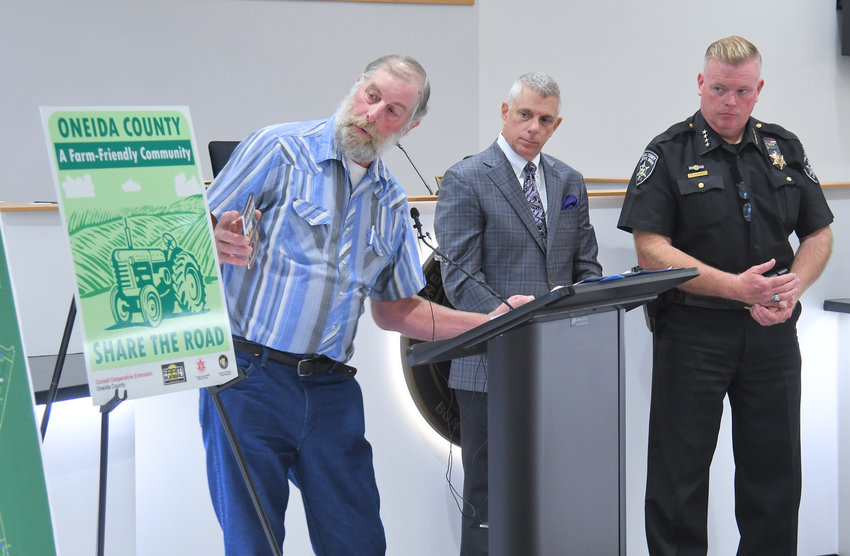 Steuben farmer Ben Simons shows one of the new Oneida County farm friendly signs as Oneida County Executive Anthony J. Picente Jr. and Oneida County Sheriff Robert M. Maciol look on during a press conference on the 10th floor of the Oneida County Office Building, 800 Park Ave. in Utica on Monday. The new signage is part of an effort to reduce accidents between vehicles and farm equipment in the county.