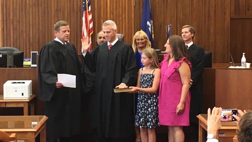 Surrounded by family and friends, Anthony J. Brindisi, with one hand raised and his other hand on the Bible, is sworn in as the new Court of Claims judge for the Utica region. The oath was administered to Brindisi by the Presiding Court of Claims Judge Richard Sise in Utica.